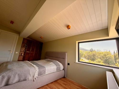a small bedroom with a bed and a window at Guesthouse near Tbilisi in Saguramo