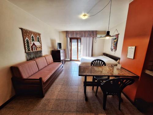 a living room with a couch and a bed and a table at Pontal Tapes Hotel in Tapes