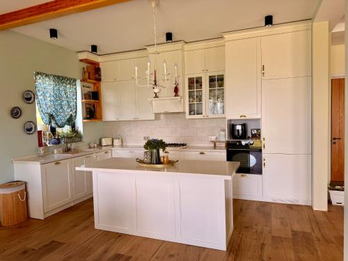 a kitchen with white cabinets and a large island at Guesthouse near Tbilisi in Saguramo