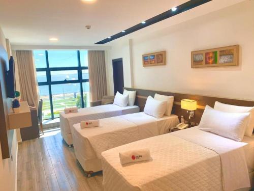 a hotel room with two beds and a window at Hotel Sun in Encarnación