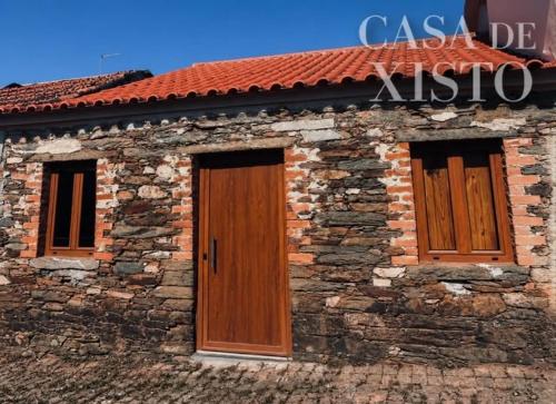 a brick building with two doors and a sign on it at MirakostaCB in Castelo Branco