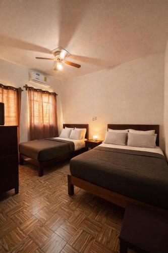 a bedroom with two beds and a ceiling fan at Hotel Ripoll Córdoba in Córdoba