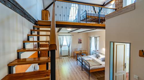 a loft apartment with a staircase and a bedroom at Penzion a Restaurace Adria II in Dobrohoř