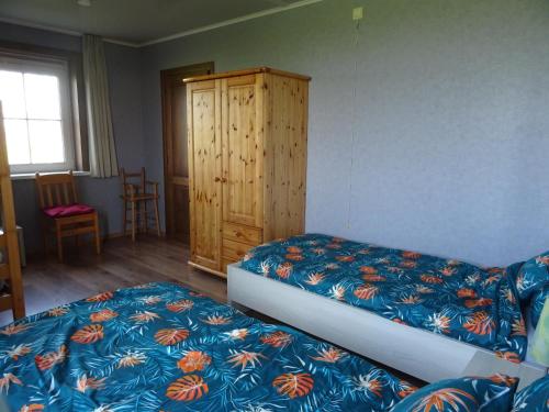 a bedroom with two beds and a wooden cabinet at Brouckmolen in Alveringem