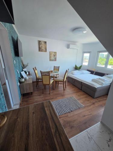 a bedroom with a bed and a table and chairs at White House Apartments - Forest in Haskovo