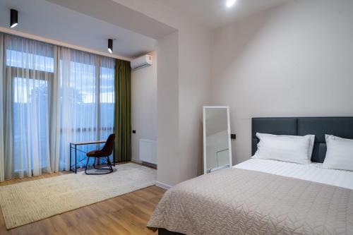a bedroom with a bed and a desk with a chair at Niabi 3BDR Villa with pool in Tbilisi City