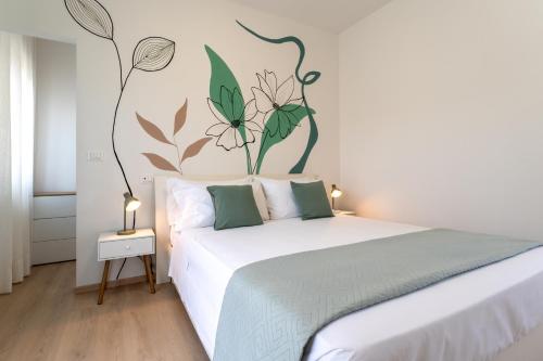 a bedroom with a white bed with flowers on the wall at Fuori Squadra in Lanciano