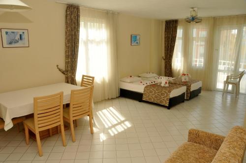 ein Wohnzimmer mit zwei Betten, einem Tisch und Stühlen in der Unterkunft Bariscan Hotel in Mahmutlar