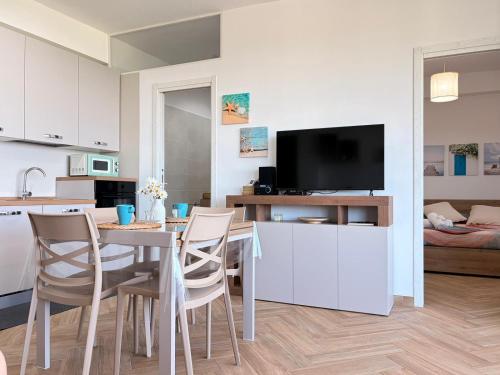 a kitchen and living room with a table and chairs at Circe Casa Vacanze in San Menaio