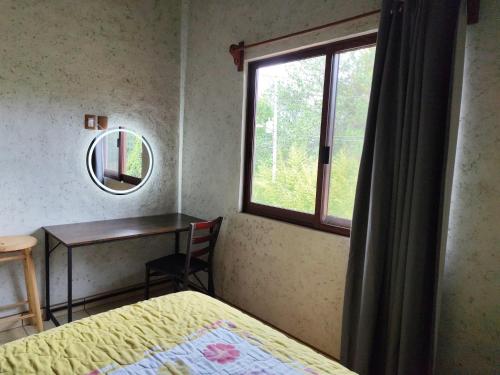 a bedroom with a bed and a desk and a window at Casa San Javier, La Loma in Tapalpa