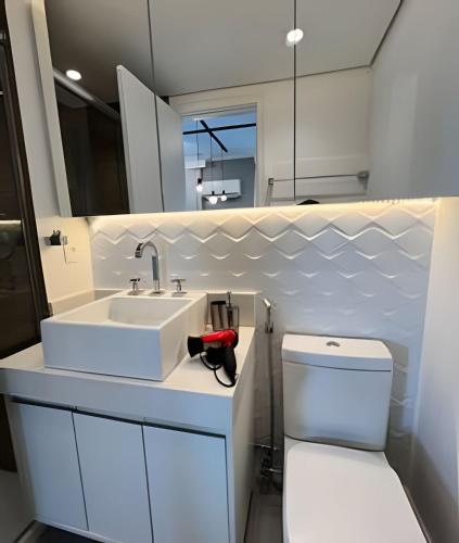 a bathroom with a white sink and a toilet at Flat Moderno c/ Vista Próx. PUC, Allianz, Pacaembu in São Paulo