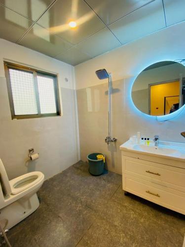 a bathroom with a toilet and a sink and a mirror at Prestige by Alnoor in Skardu