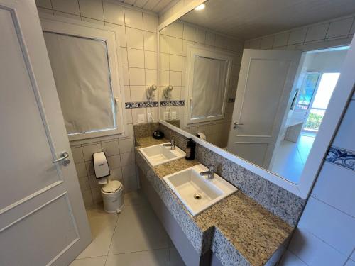 a bathroom with two sinks and a mirror at Hotel Vila do Farol in Bombinhas