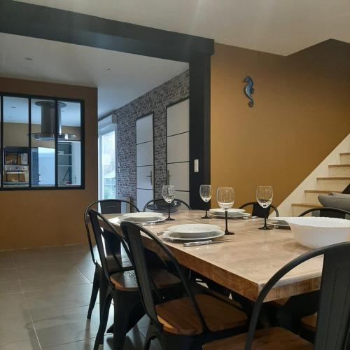 a dining room with a table with wine glasses at OF08 - Maison entre mer et forêt in Oust-Marais