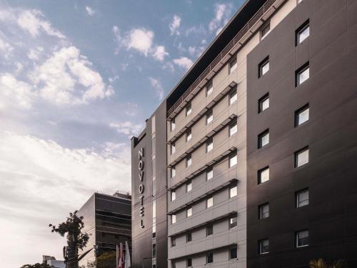 a tall gray building with a sky in the background at Novotel Lima San Isidro in Lima