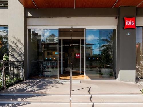 an entrance to a building with ahs sign on the door at ibis Navegantes Itajai in Itajaí