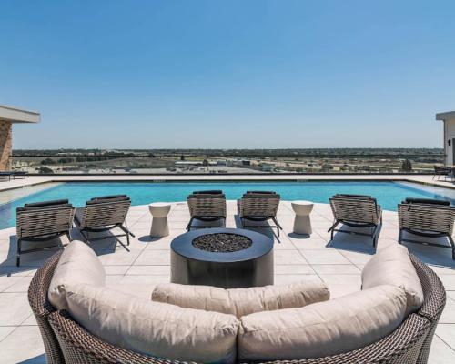 a patio with a couch and chairs and a pool at Excel Grand Stays in Frisco