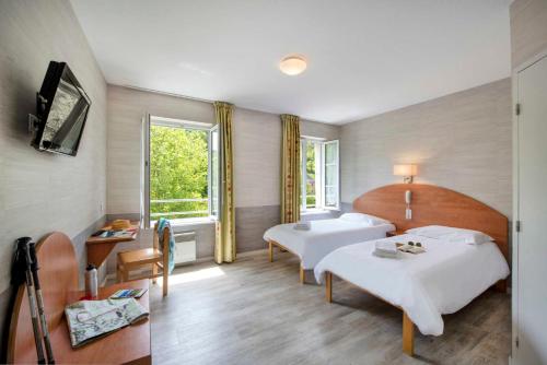 a hotel room with two beds and a window at Village Vacances L'Oustal in Salles-la-Source
