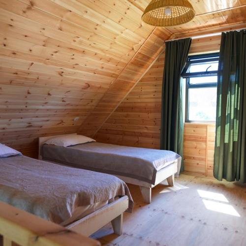 a bedroom with two beds in a log cabin at Silence Houses in Tossor
