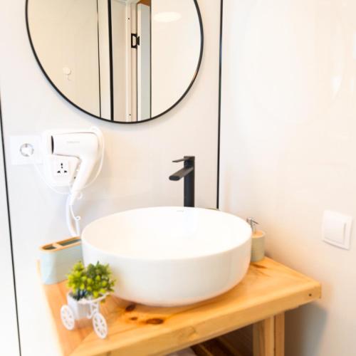 a bathroom with a white sink and a mirror at Silence Houses in Tossor