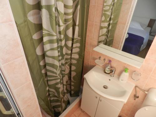 a bathroom with a sink and a shower curtain at Apartments Lea in Orebić