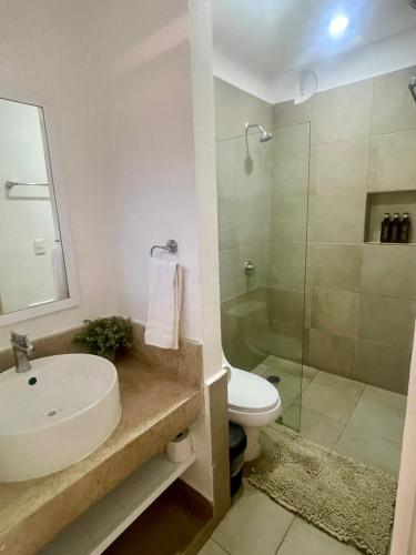 a bathroom with a sink and a toilet and a shower at Isla Lorens in Isla Mujeres