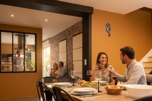 a group of people sitting at a table with wine glasses at OF08 - Maison entre mer et forêt in Oust-Marais