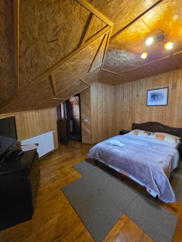 a bedroom with a large bed and a wooden ceiling at Cabana Magdalena in Câmpulung