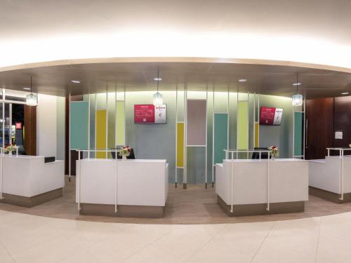 a lobby with colorful glass walls and white counters at Ibis Phuket Patong in Patong Beach