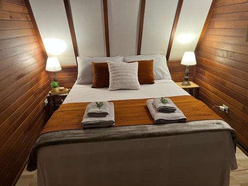 a bedroom with a large bed with towels on it at Chalé Rancho Ouro Verde in Rolândia