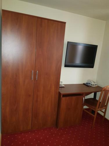 a room with a desk and a large wooden cabinet at Hotel Iris in Arad