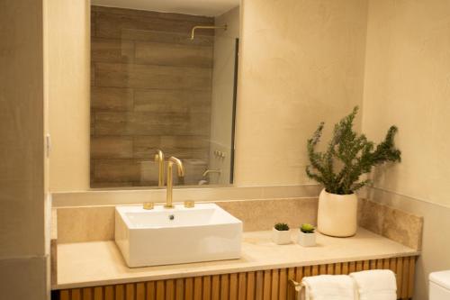 a bathroom with a white sink and a mirror at Atelier Petit Hotel in Ciudad Lujan de Cuyo