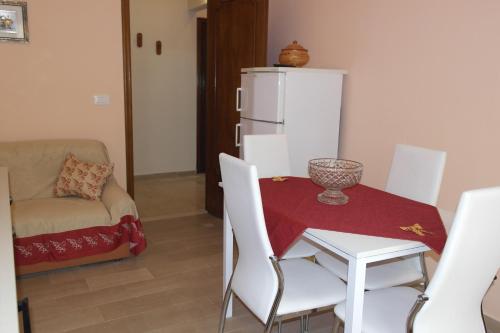 a dining room with a table and a white refrigerator at Appartamenti Naxos in Giardini Naxos