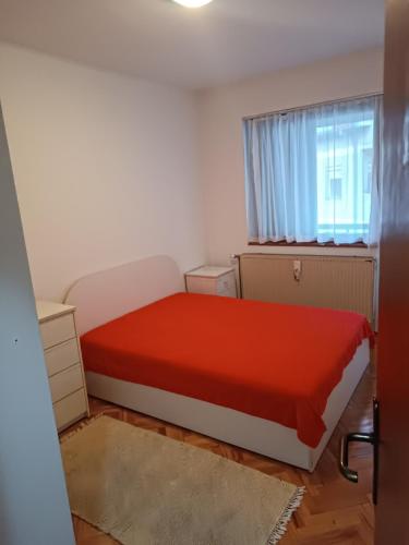 a small bedroom with a red bed and a window at Lake and Forrest in Belgrade