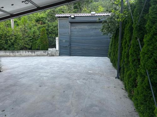 a parking lot with a garage with a door at Mountain Panorama Garden BBQ ECO in Shumen