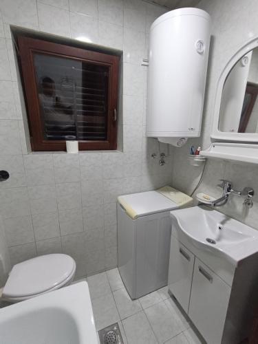 a white bathroom with a toilet and a sink at Lake and Forrest in Belgrade