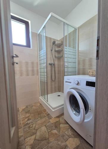 eine Waschmaschine in einem Badezimmer mit Dusche in der Unterkunft Smart Ghimbav in Ghimbav