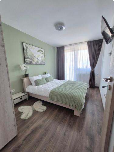 ein Schlafzimmer mit einem großen Bett und Holzböden in der Unterkunft Smart Ghimbav in Ghimbav