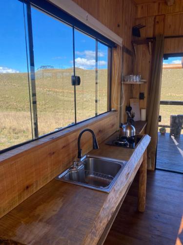a kitchen with a sink and a large window at Cloud Valley in Bom Jardim da Serra