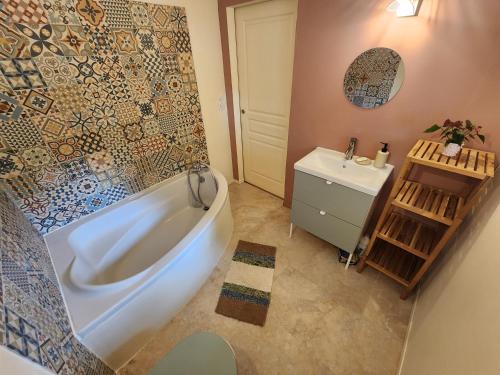 a bathroom with a white tub and a sink at Le Gîte du Moulin in Saint-Maigrin