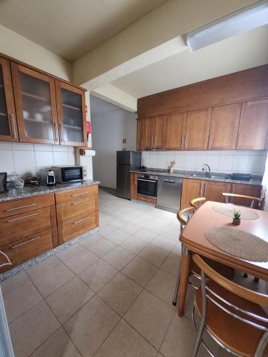 a large kitchen with wooden cabinets and a table at A Romãzeira in Torre de Moncorvo