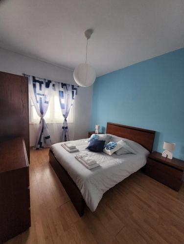 a bedroom with a large bed with blue walls at A Romãzeira in Torre de Moncorvo