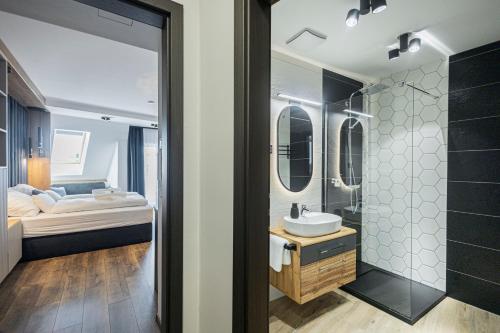 a bathroom with a sink and a shower and a bed at ELYX Home Apartmanok in Sárvár