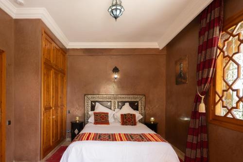 a bedroom with a bed and a window at Villa privée, 5 suites, Piscine & Jardin XXL in Marrakesh