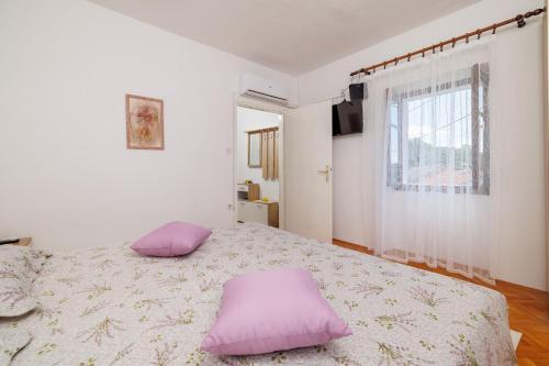 a bedroom with a bed with two pillows on it at House Katica in Grižane