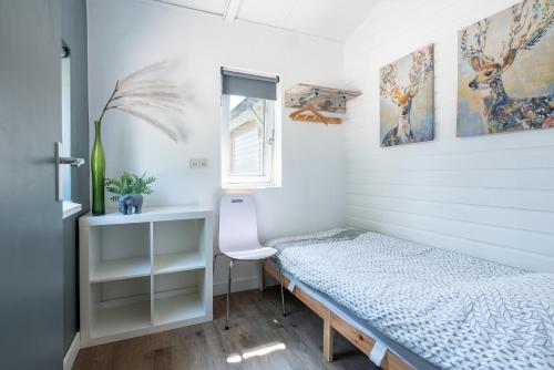 a small bedroom with a bed and a window at Chalet Achterbosch in Lieshout