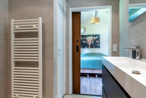a bathroom with a door leading to a bedroom at Chalet Achterbosch in Lieshout