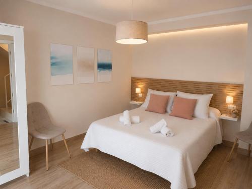 a bedroom with a white bed with two towels on it at Casa Papel y Pluma in Cazorla