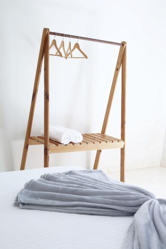 a wooden towel rack next to a bed at Suite Areal in Atins