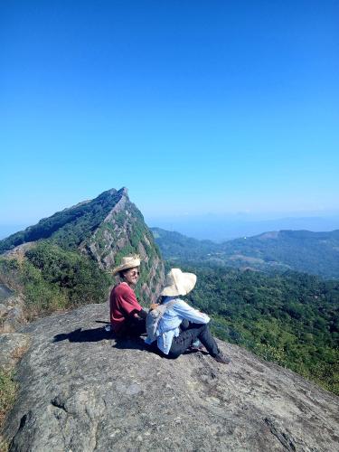 a man and woman sitting on top of a mountain at The Off Road Homestay in Kandy